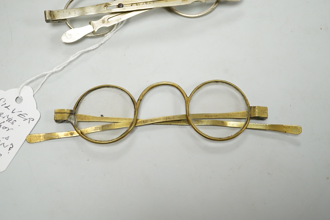 Three pairs of early 19th century base metal slider spectacles, pseudo hallmarks, one also stamped Pebbles, and two pairs of similar temple spectacles, the pair with turn pin sides also stamped pebbles, the pair with obl